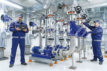 Leadec employees working at pumps of compressor unit.